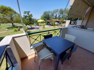 a balcony with a blue table and chairs on it at Elia Apartments in Oreoi