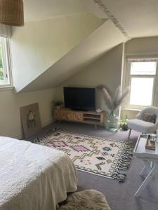 a bedroom with a bed and a flat screen tv at The Loft, Farnham, Surrey in Farnham