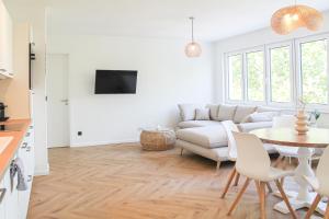 a living room with a white couch and a table at Relax Apartment - für Familien, stadtnah, mit Parkplatz in Koblenz