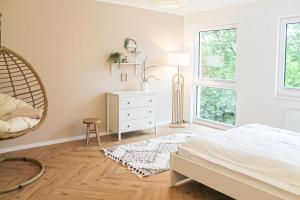a bedroom with a bed and a dresser and windows at Relax Apartment - für Familien, stadtnah, mit Parkplatz in Koblenz