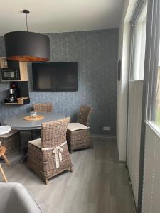 a dining room with a table and chairs and a tv at Ferienwohnung Strandkieker 2 in Ueckermünde +3 photos