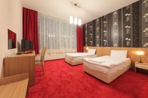 sypialnia z 2 łóżkami i czerwonym dywanem w obiekcie Sky Hotel w mieście Wielkie Tyrnowo