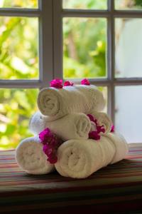 una pila di asciugamani con fiori rosa di Fond Doux Eco Resort a Soufriere