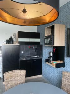 a kitchen with a sink and a counter with chairs at Ferienwohnung Strandkieker 2 in Ueckermünde