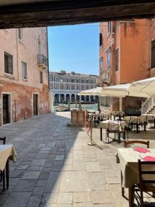 an empty courtyard with tables and chairs and buildings at Remer Suites in Venice
