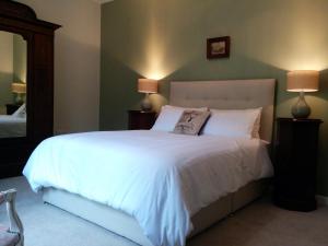 um quarto com uma grande cama branca e 2 candeeiros em Narrow Water Castle Self Catering Accommodation em Warrenpoint