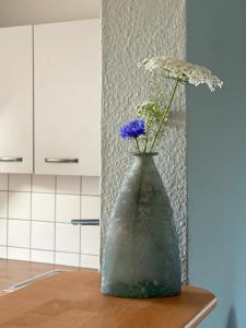 a vase with flowers on a table in a kitchen at Auszeit in Hürup