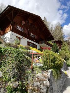 ein großes Holzhaus mit einem Schild davor in der Unterkunft Waldruhe in Jaun