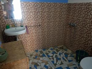 a bathroom with a sink and a toilet at Campement Baobab in Poponguine