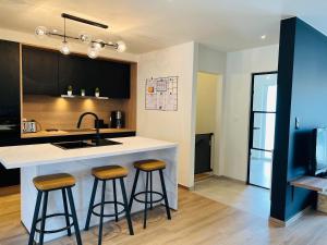 a kitchen with two bar stools at a kitchen island at Vakantiewoning De Winning in Houthalen-Helchteren