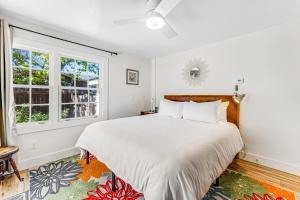 1 dormitorio blanco con 1 cama grande y 2 ventanas en Red Rooster Cottage, en Windsor
