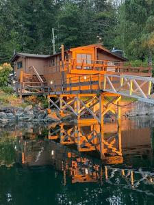 an orange house on a bridge over a body of water at April Point Harbour House in Quathiaski Cove