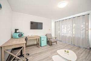 a room with a desk and a computer and a chair at Founder's Brook Motel and Suites in Portsmouth