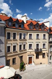 ein großes, braunes Gebäude mit rotem Dach in der Unterkunft Hotel Alter in Lublin