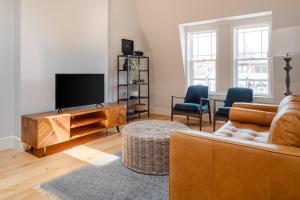 a living room with a couch and a flat screen tv at Sonder The Magnolia in Boston