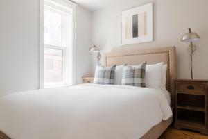 sypialnia z białym łóżkiem z poduszkami i oknem w obiekcie Sonder The Magnolia w mieście Boston