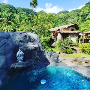 een zwembad in een resort met een standbeeld in het water bij Soul Rise in Taravao
