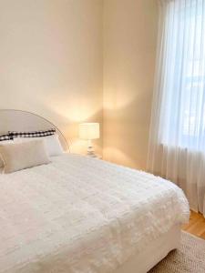 a bedroom with a white bed and a window at BIRCHWOOD ON BRIDGE in Tanunda