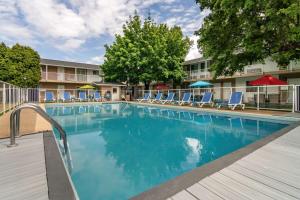 una piscina en un hotel con sillas y árboles en Best Western Inn at Penticton, en Penticton