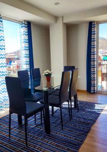 a dining room with a table and chairs on a rug at Buena Vista Apartment in Cusco