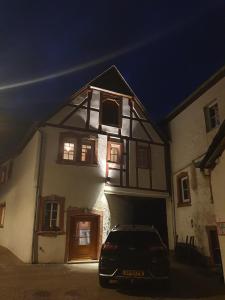 un coche aparcado delante de una casa por la noche en Haus zur Heugabel, en Kesten