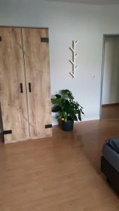um quarto com duas portas de madeira e um vaso de plantas em Dithmarscher Haus em Marne