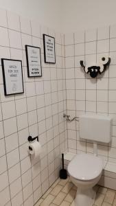a bathroom with a toilet and signs on the wall at Dithmarscher Haus in Marne