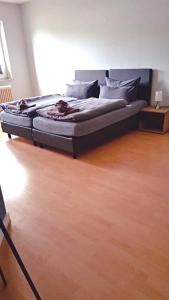 a large bed in a room with a wooden floor at Dithmarscher Haus in Marne