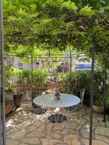 een patio met een tafel en stoelen onder een boom bij Villa avec piscine en plein cœur de ville in Montpellier