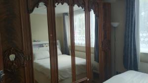 a bedroom with a large wooden cabinet with a bed at 119 the shaftesbury in Barking