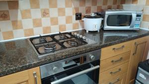 a kitchen with a stove top oven next to a microwave at 119 the shaftesbury in Barking