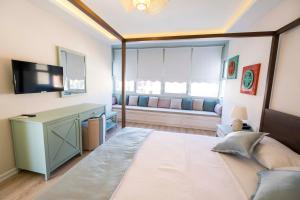 a living room with a large bed and a television at İcarus Alaçatı in Çeşme