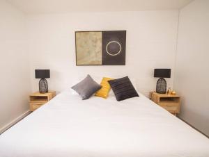 ein Schlafzimmer mit einem großen weißen Bett mit zwei Nachttischen in der Unterkunft Willow Court Unit 1 in Broken Hill