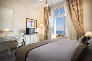 una camera da letto con un letto, una scrivania e una finestra di Hotel Kvarner - Liburnia a Opatija