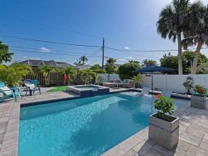 a swimming pool with blue water in a yard at Sanctuary Home Naples-Private Pool and Lanai! in Naples