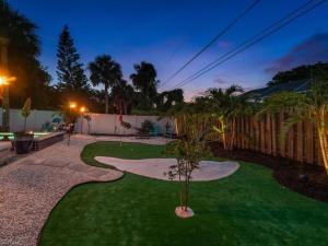 a backyard with a green yard with a walkway at Sanctuary Home Naples-Private Pool and Lanai! in Naples