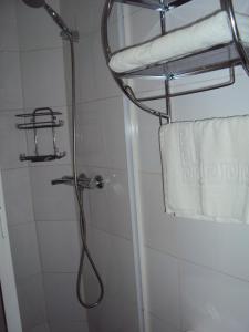 a shower with a shower head and a towel at Apart Hotel Cancura in Chillán