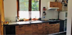 a kitchen with wooden cabinets and a black counter top at Wiolinkowo in Sarnaki
