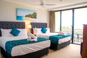 a hotel room with two beds and a balcony at Cairns Luxury Waterview Apartment in Cairns