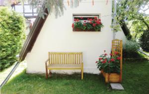 a bench in a yard with a window and flowers at 2 Bedroom Lovely Home In Badersleben in Badersleben