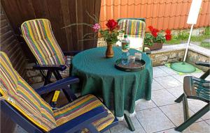 a table with two chairs and a vase of flowers at 2 Bedroom Lovely Home In Badersleben in Badersleben