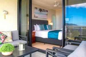 Cairns Luxury Waterview Apartment في كيرنز: غرفة نوم بسرير وشرفة