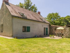 a house with a green door and a patio at Gîte Saint-Lyphard, 4 pièces, 6 personnes - FR-1-306-1093 in Saint-Lyphard