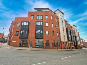 a red brick building on the corner of a street at Lovely 1 Bedroom Apartment - Bham City Centre in Birmingham