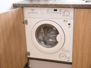 a washing machine in a kitchen under a counter at Lovely 1 Bedroom Apartment - Bham City Centre in Birmingham