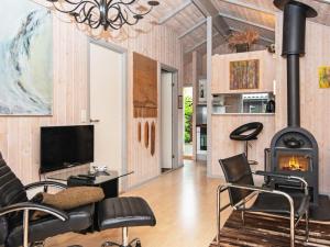 a living room with a fireplace and a tv at Holiday Home Lærkevej VI in Ebeltoft