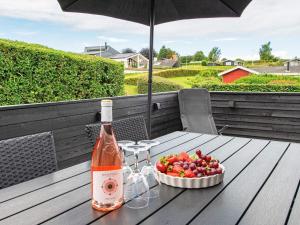 a bottle of wine and a bowl of fruit on a table at 5 person holiday home in Hejls in Hejls