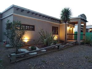 una casa con una palmera delante de ella en Brisas de viñedos en Luján de Cuyo