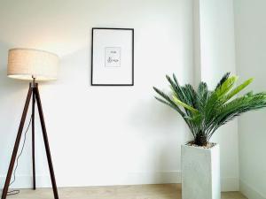 a lamp and a plant in a room with a picture at Lovely 2 bedroom downtown suite with free parking in Victoria