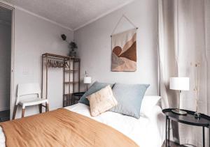 a bedroom with a bed and two tables and a chair at Bay Properties Pacific Sun in Yamba